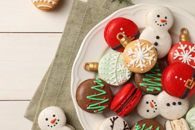 Beautifully decorated Christmas macarons on white wooden table, flat lay