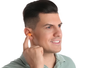 Man inserting foam ear plug on white background