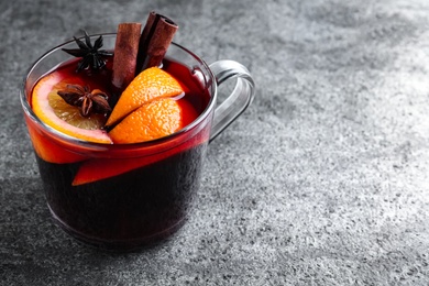 Aromatic mulled wine on grey table. Space for text