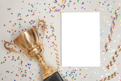 Trophy and blank paper on light background, top view with space for text. Victory concept