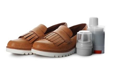 Stylish footwear and shoe care products on white background