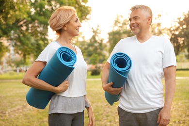 Couple with yoga mat in park at morning