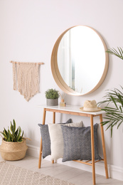 Photo of Round mirror and wooden table at home. Idea for interior design