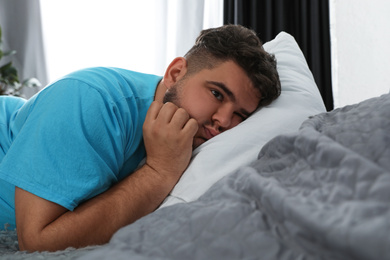 Overweight man suffering from depression on bed
