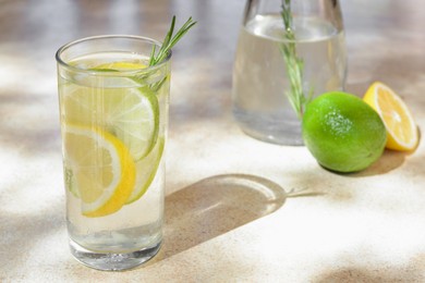 Photo of Tasty refreshing lemonade and ingredients on light table, space for text. Summer drink
