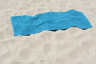 Soft blue towel on sandy beach, space for text