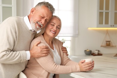 Happy senior couple spending time together in kitchen