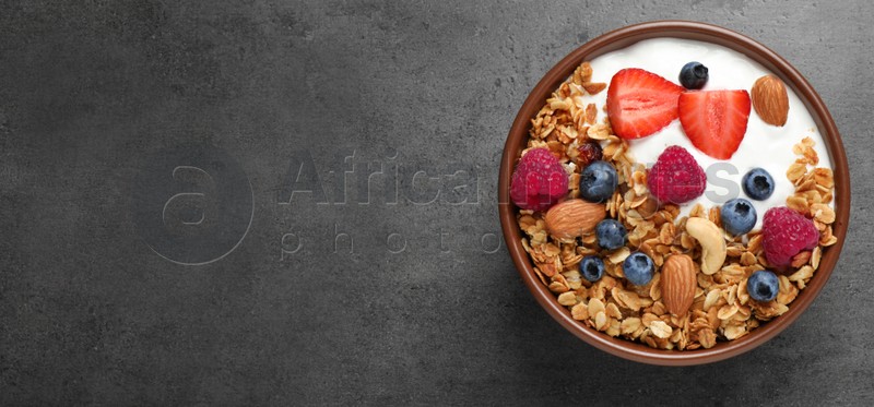 Tasty homemade granola with berries served on grey table, top view with space for text. Banner design