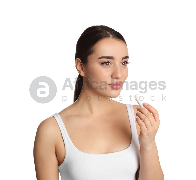 Young woman with lip balm on white background