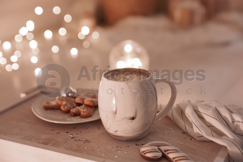 Cup of tasty hot drink and cookies on wooden table. Christmas atmosphere