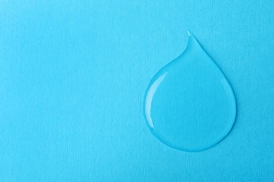 Photo of Drop on light blue background, top view. Save water concept