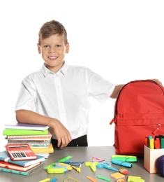 Photo of Schoolboy at table with stationery against white background