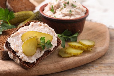 Photo of Sandwich with delicious lard spread and pickles on wooden table, closeup
