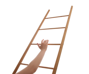 Photo of Woman climbing up wooden ladder against white background, closeup