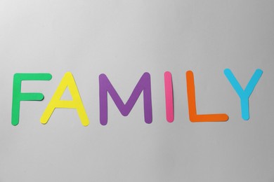 Word Family made of colorful paper letters on grey background, flat lay