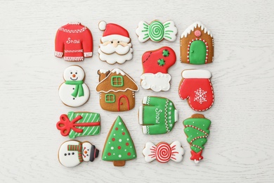 Different Christmas gingerbread cookies on white wooden table, flat lay
