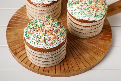 Photo of Traditional Easter cakes with sprinkles on white wooden table