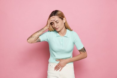 Photo of Young woman suffering from menstrual pain on pink background