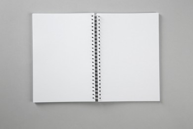 Open blank notebook on grey background, top view. Mockup for design