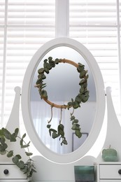 Photo of Stylish dressing table decorated with beautiful eucalyptus branches indoors