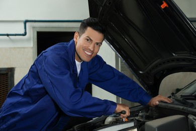 Photo of Professional mechanic fixing modern car at automobile repair shop