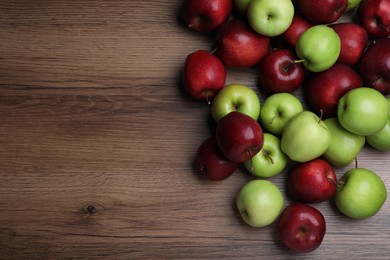 Photo of Fresh ripe red and green apples on wooden table, flat lay. Space for text