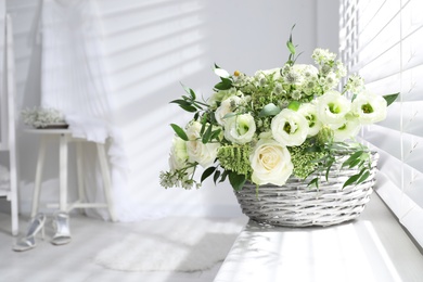 Basket with beautiful wedding flowers on window sill in room