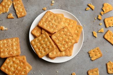 Delicious crispy crackers on grey table, flat lay