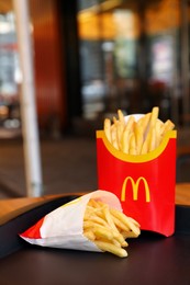 MYKOLAIV, UKRAINE - AUGUST 11, 2021: Big and small portions of McDonald's French fries on tray in cafe