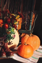 Beautiful bouquet, pumpkins and boots on table indoors