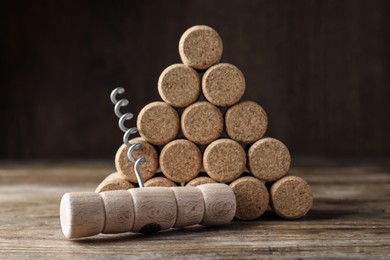 Corkscrew and wine corks on wooden table