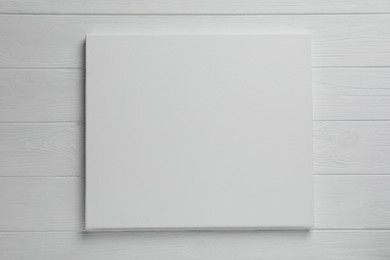 Blank canvas on white wooden background, space for text