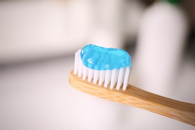 Toothbrush with paste on blurred background, closeup