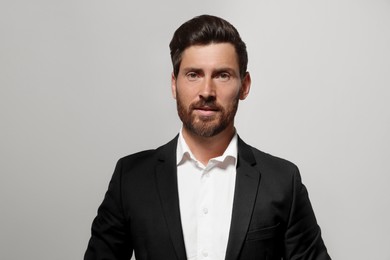 Photo of Portrait of handsome bearded man in suit on light grey background
