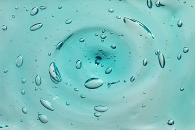 Turquoise facial gel as background, closeup view
