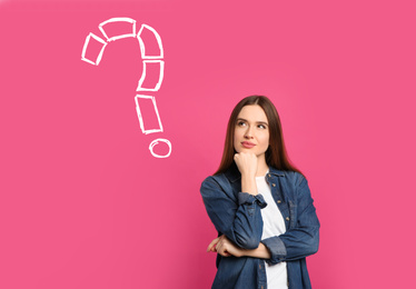 Emotional woman with drawing of question mark on pink background