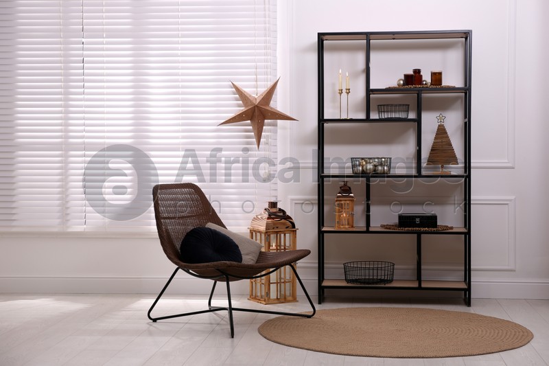 Photo of Stylish room interior with shelving unit and Christmas decor. Modern design