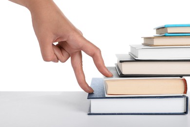 Woman imitating stepping up on books with her fingers against white background, closeup