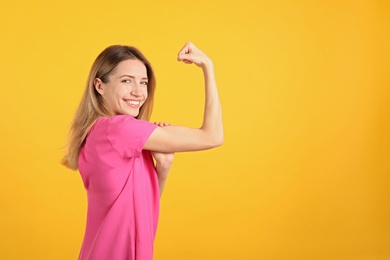 Strong woman as symbol of girl power on yellow background, space for text. 8 March concept