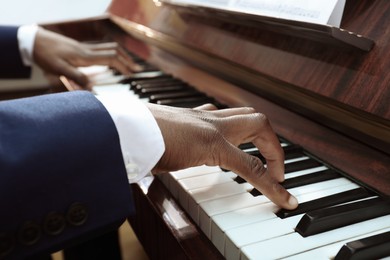African-American man playing piano, closeup. Talented musician