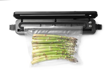 Sealer for vacuum packing with plastic bag of asparagus on white background, top view
