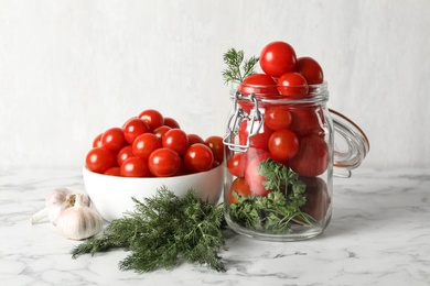 Pickling jar with fresh ripe cherry tomatoes on white marble table