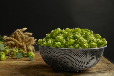 Photo of Fresh green hops and spikes on wooden table