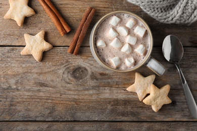 Composition with delicious hot cocoa drink and cookies on wooden background, flat lay