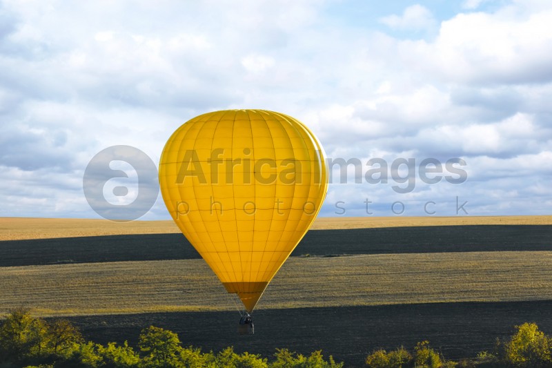 Colorful hot air balloon flying over field