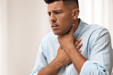 Man suffering from pain during breathing indoors