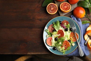 Delicious sicilian orange salad served on wooden table, flat lay. Space for text