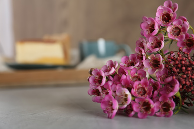 Bouquet of beautiful spring flowers on grey table, closeup. Space for text