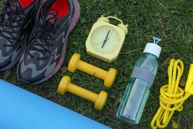 Photo of Set for morning exercise on green grass, flat lay