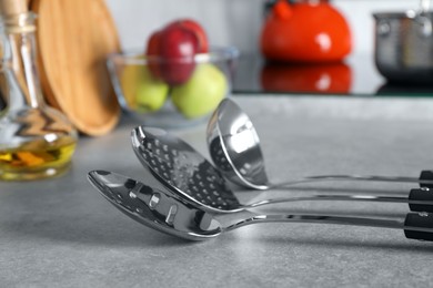 Set of different cooking utensils on grey countertop in kitchen, closeup